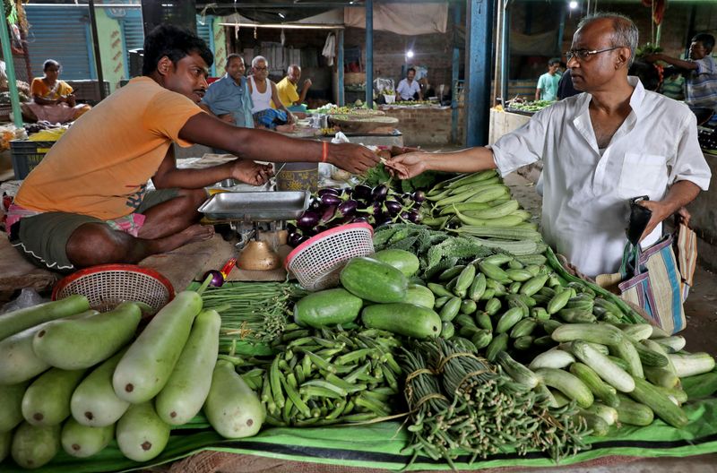 Nikhil Kumar Mondal buys vegetables from a vendor at a