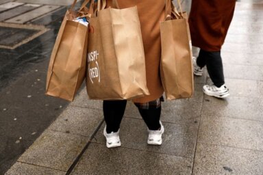 A shopper holds several bags after coming out of a