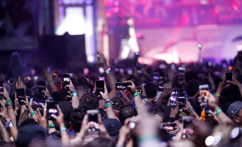 FILE PHOTO:  Concertgoers use their mobile phones during Eminem’s