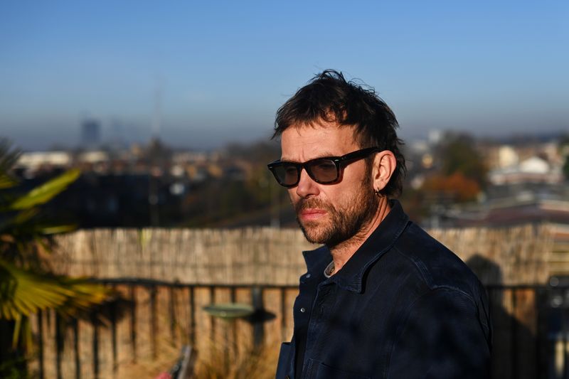 British musician Albarn enjoys the morning sun outside his studio