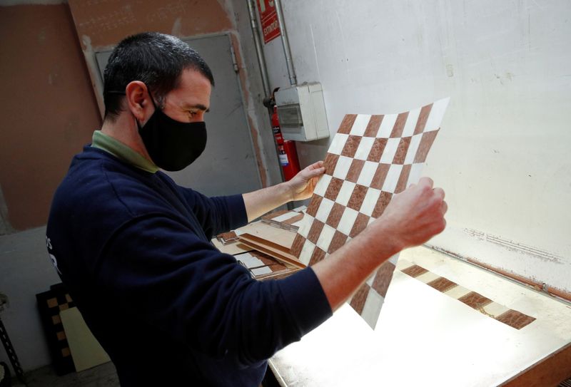 A worker makes a chessboard at the Rechapados Ferrer factory