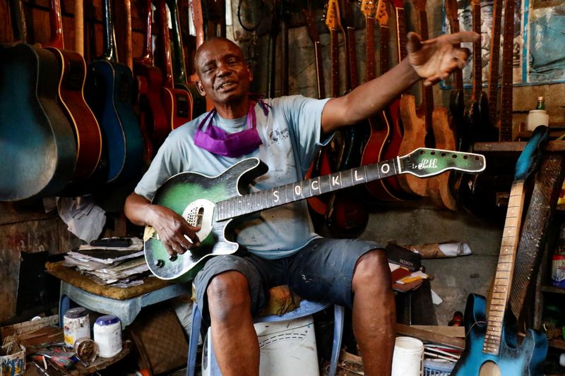 Guitar luthier Misoko Nzalayala Jean-Luther, alias Socklo, holds one of