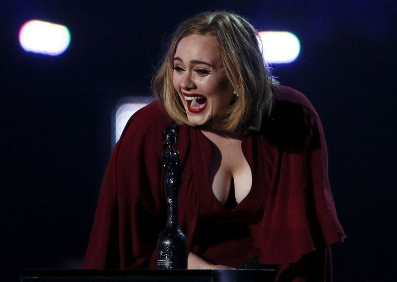 FILE PHOTO: Adele reacts as she accepts the global success
