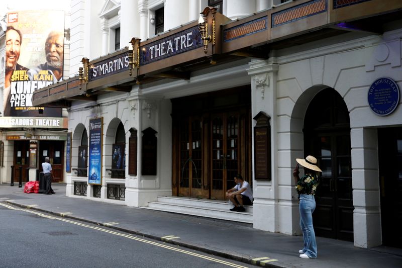 FILE PHOTO: People stand next to St Martin’s Theatre at