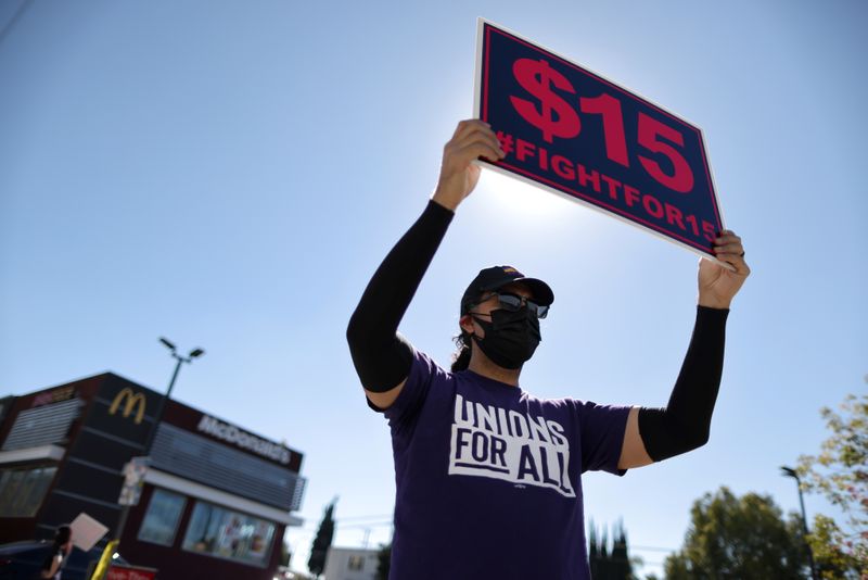 FILE PHOTO: A man holds a minimum wage sign at