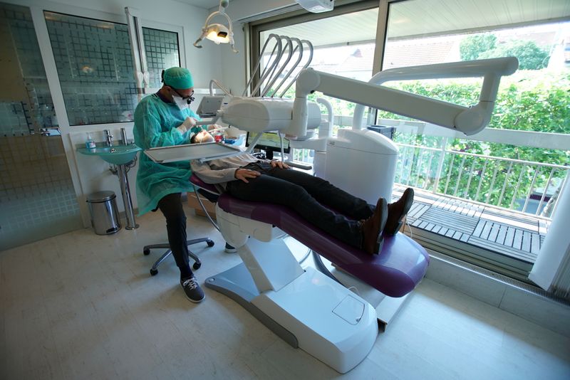 FILE PHOTO: A dental surgeon, wearing a protective face mask,