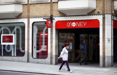 FILE PHOTO: People walk past a Virgin Money store in