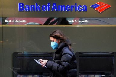 FILE PHOTO: Person walks past a Bank of America sign