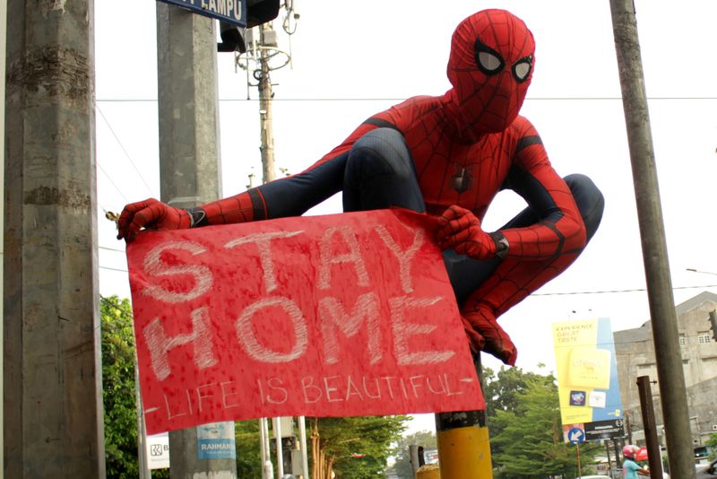 FILE PHOTO: A volunteer wearing a Spiderman costume carries a