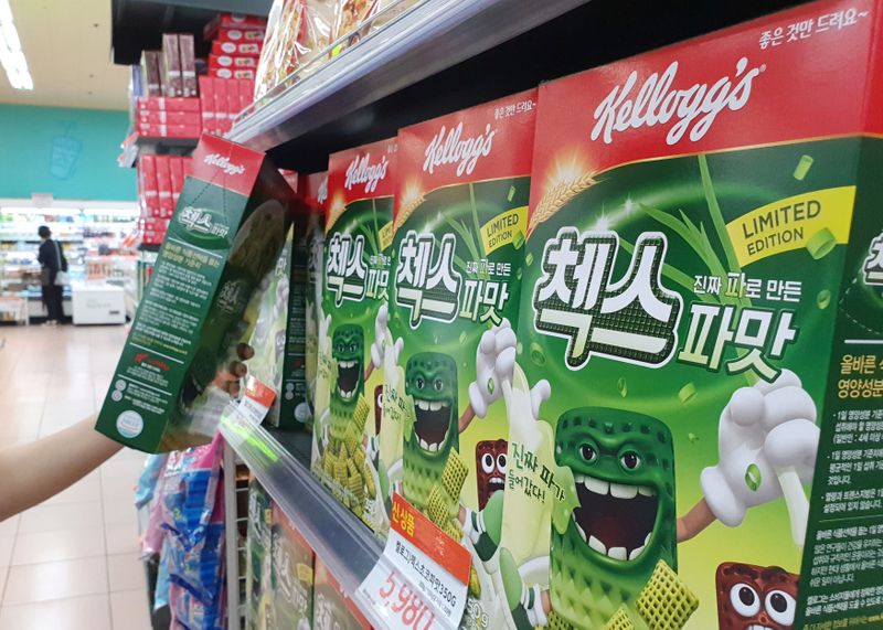 A clerk displays Kellogg’s green onion-flavored cereal at a supermarket