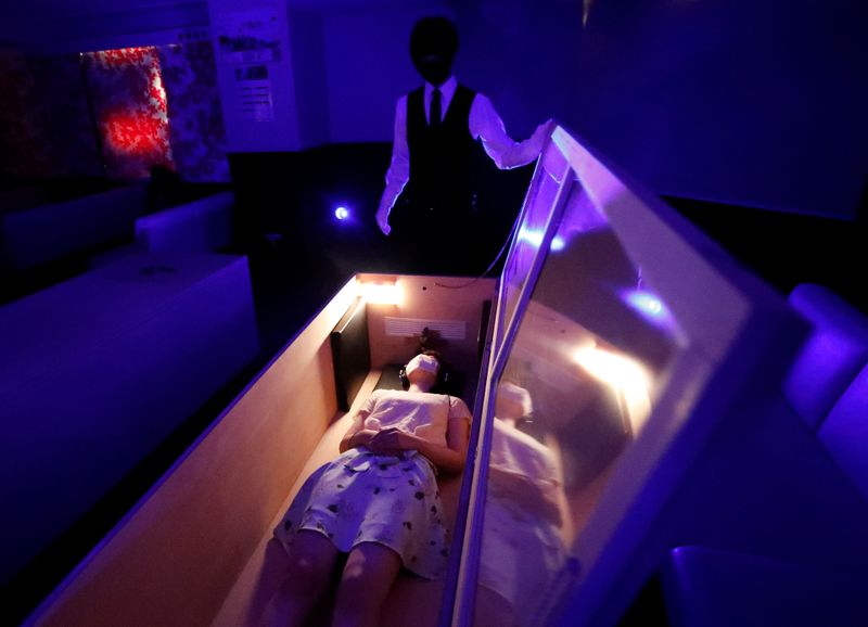 A participant lies inside a mock of coffin with plastic