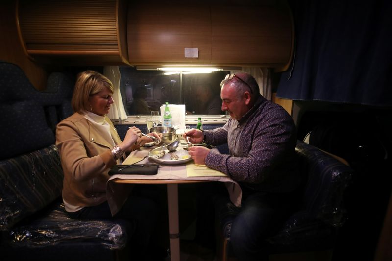 Customers enjoy dinner sitting inside a motorhome camper parked at