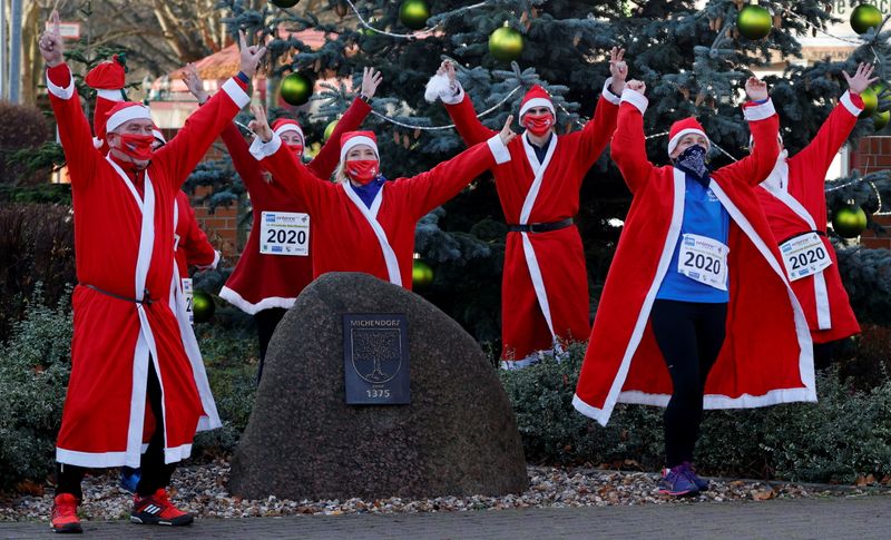 People dressed as Santa Claus race through the streets of