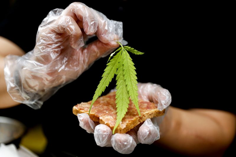 A chef prepares a pork sandwich with a marijuana leaf