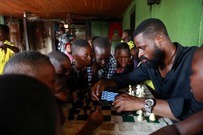 Babatunde Onakoya, 26, teaches children to play chess at a