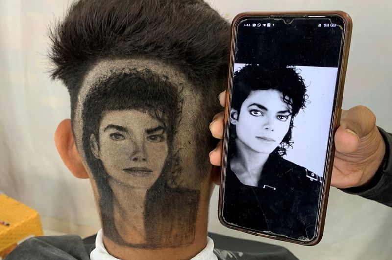 Gurwinder Singh Sidhu, a barber, displays a photo of Michael