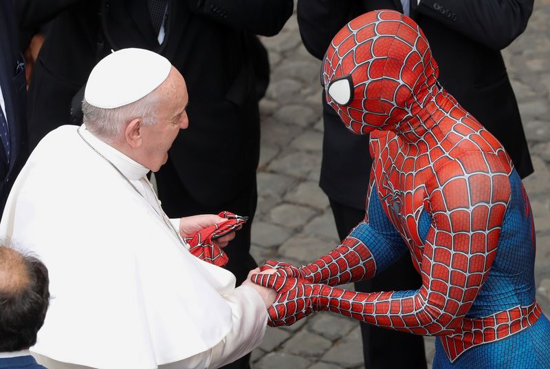 Pope Francis greets a person dressed as Spiderman, at the