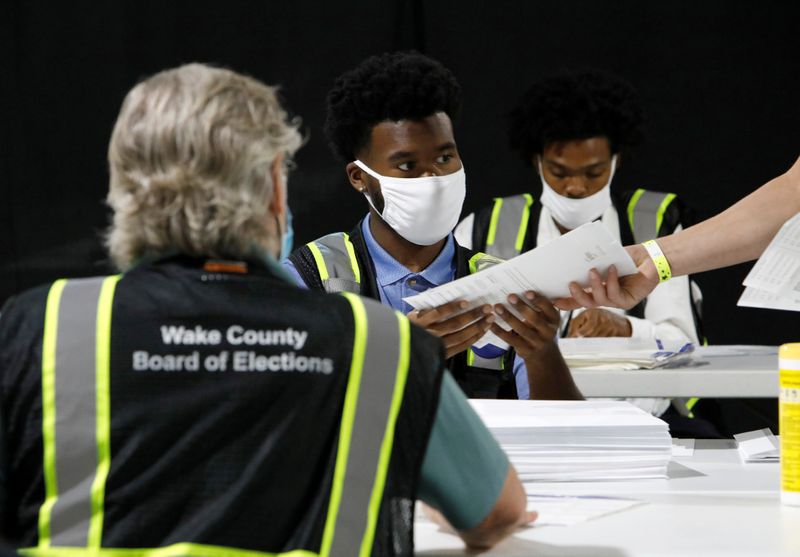 FILE PHOTO: : Poll workers prepare absentee ballots for the