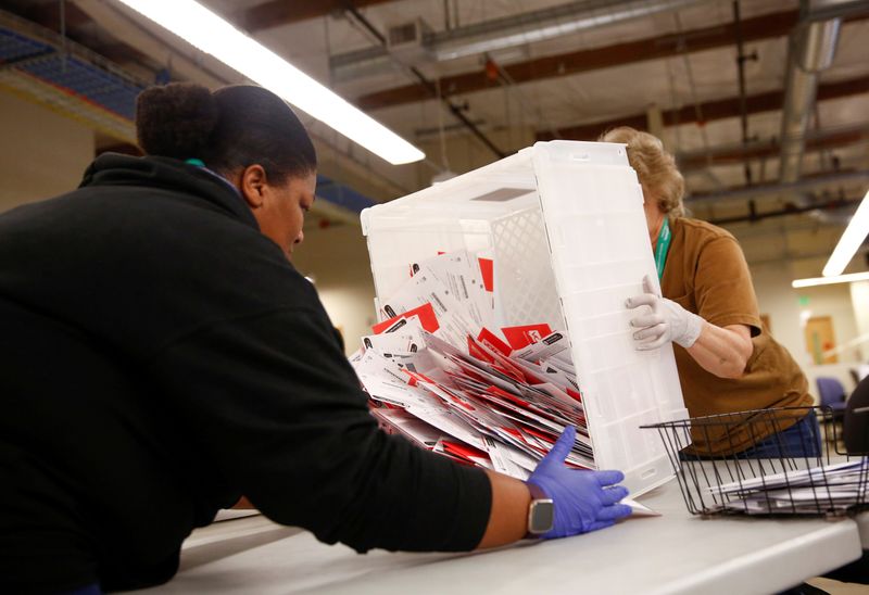 FILE PHOTO: Workers empty a carton of ballots from a