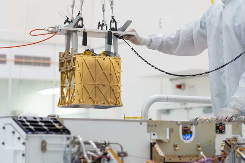 Technicians at NASA’s Jet Propulsion Laboratory lower the Mars Oxygen
