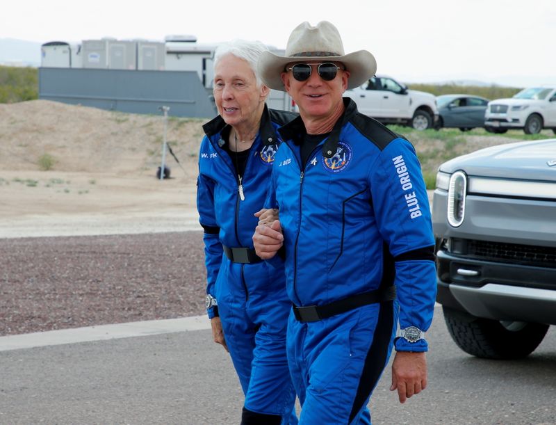 Billionaire American businessman Jeff Bezos walks with crewmate Wally Funk