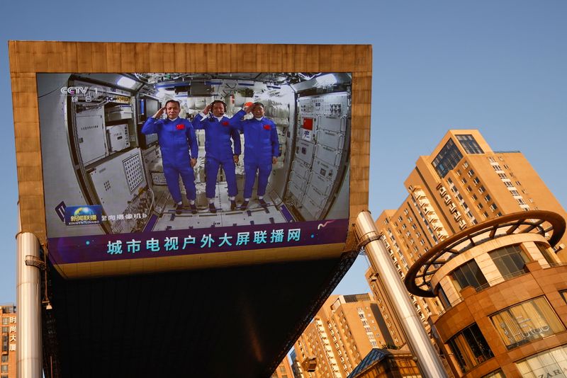 FILE PHOTO: A giant screen shows Chinese astronauts of the
