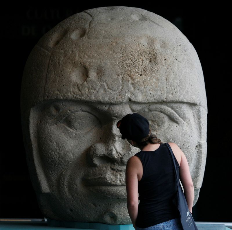 FILE PHOTO: Visitor looks at an Olmec colossal head during