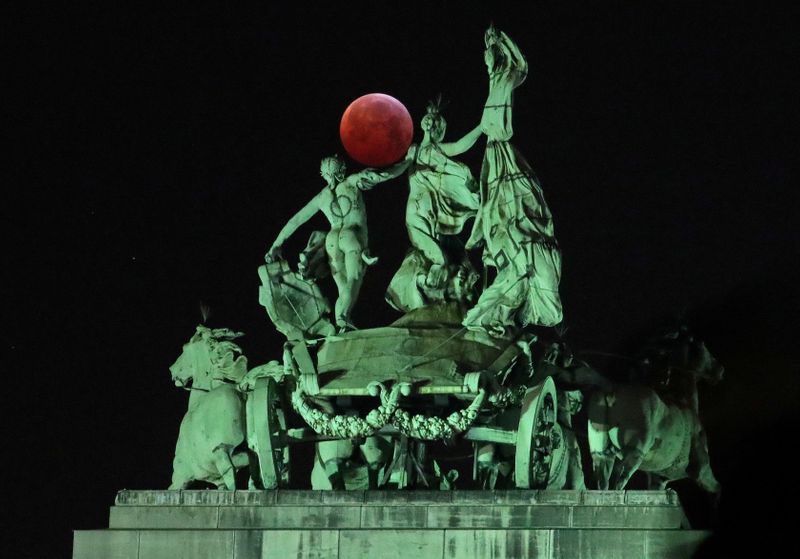 FILE PHOTO: The moon is seen beside a quadriga on