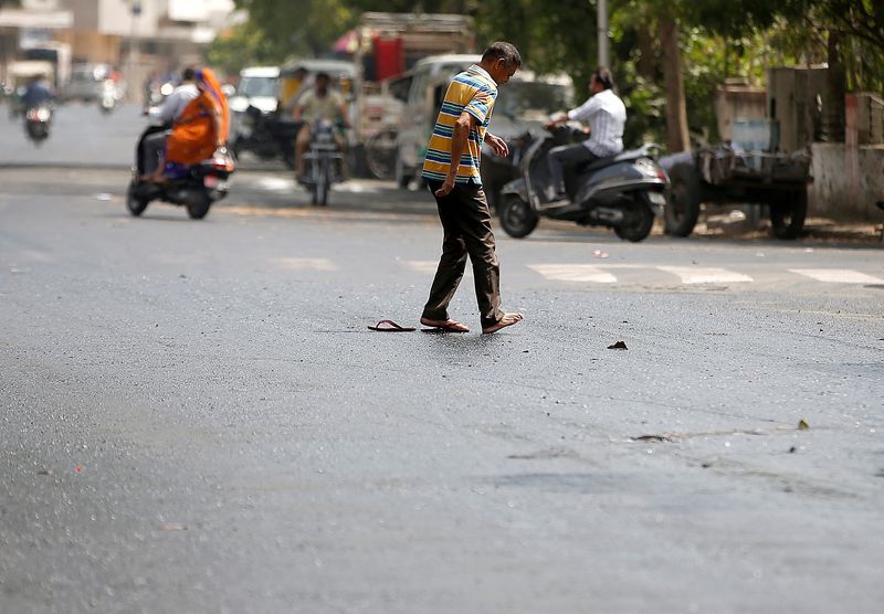 A man struggles to cross a road after his slippers