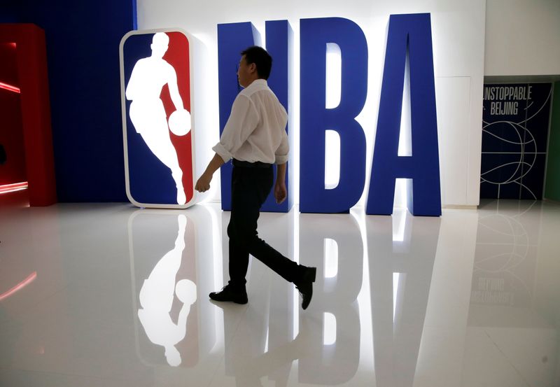 A man walks past an NBA logo at an NBA