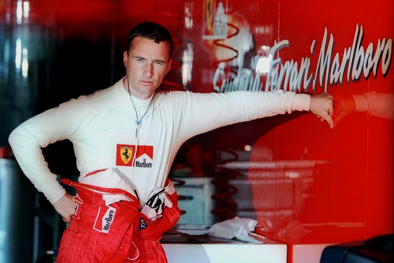 FILE PHOTO: Ferrari driver Eddie Irvine cools off during the