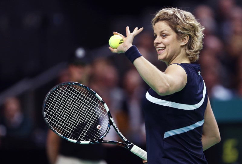 Belgium’s Clijsters waves to supporters during an exhibition tennis match