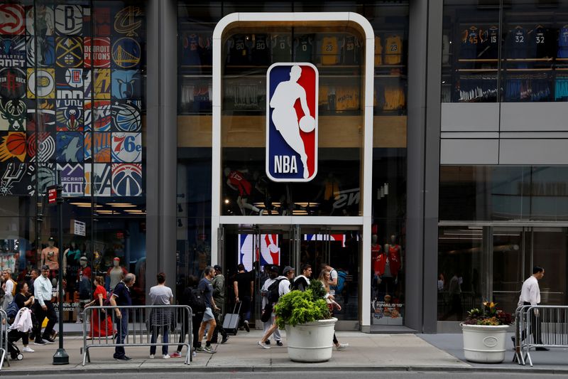 FILE PHOTO: The NBA logo is displayed as people pass