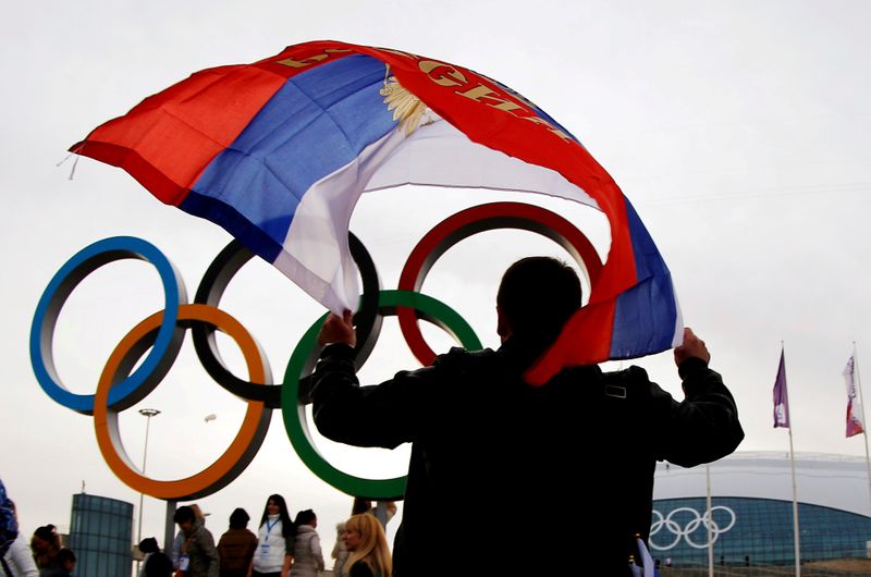 FILE PHOTO: Man carries the Russian flag past the Olympic