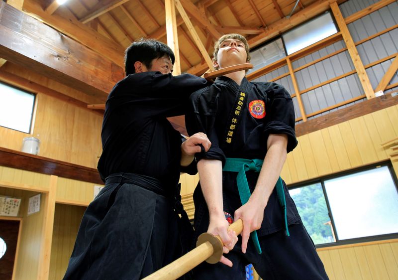 Genichi Mitsuhashi teaches martial arts to a guest in a