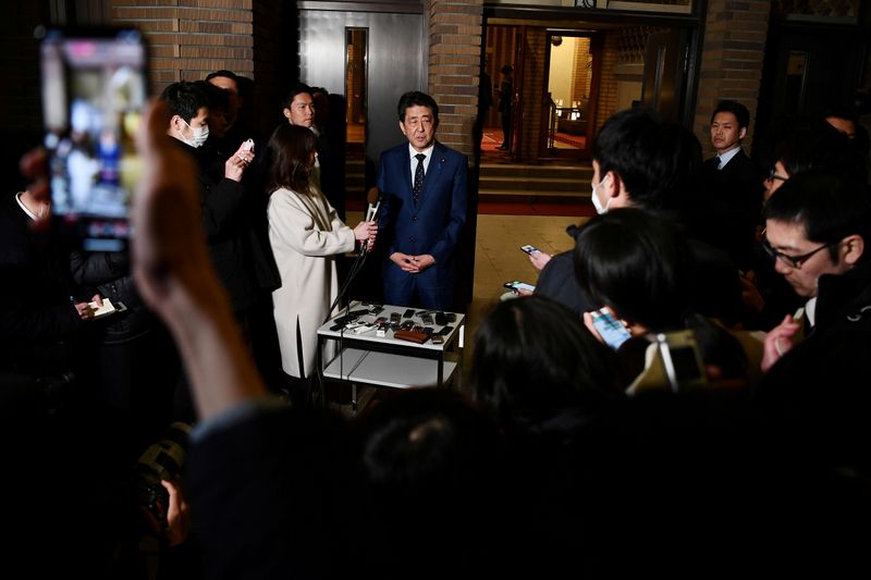 FILE PHOTO: Japan’s Prime Minister Shinzo Abe talks to the