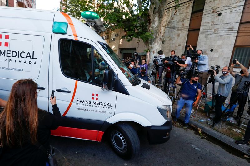 An ambulance carrying Diego Maradona leaves the clinic where Maradona