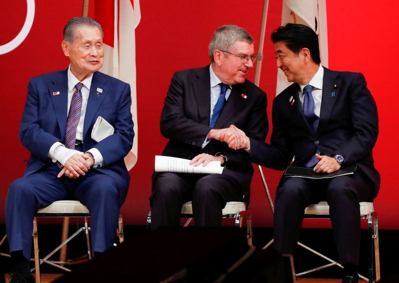 FILE PHOTO: IOC President Bach shakes hands with Japan’s PM