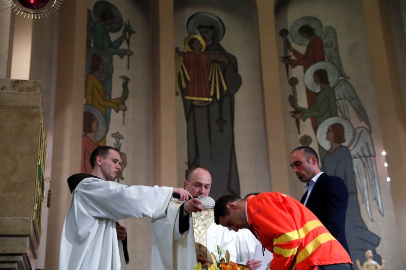 A Franciscan priest baptizes the triathlon champion Vanek as a