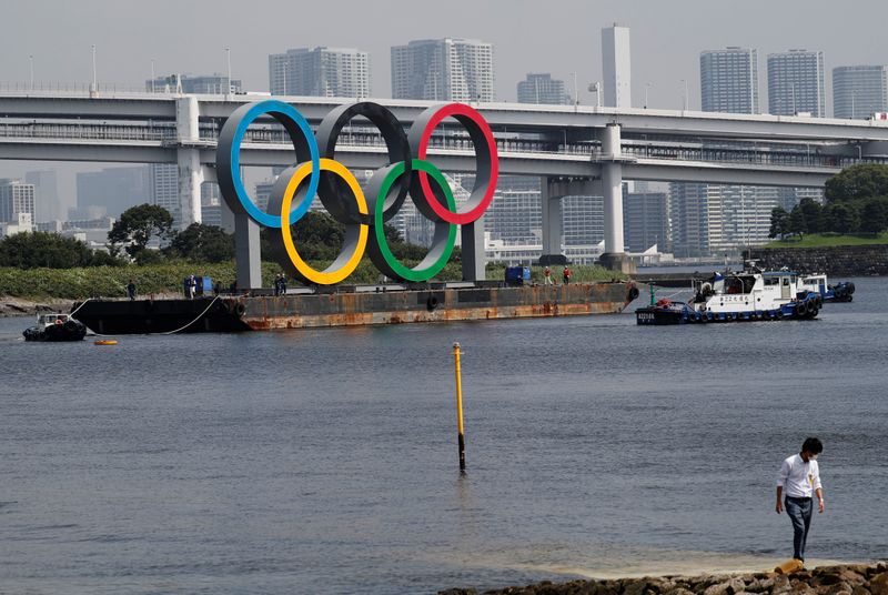 Boats tow the giant Olympic rings, which are being temporarily