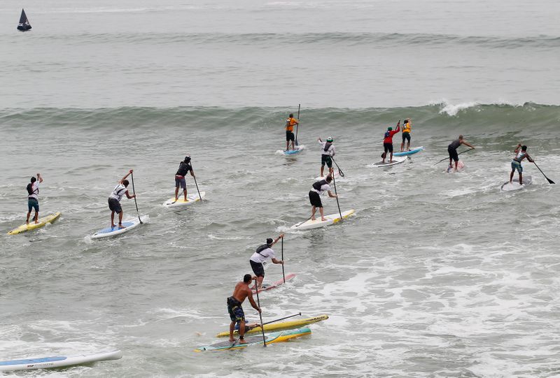 FILE PHOTO: Paddle board surfers compete in the Distance Race
