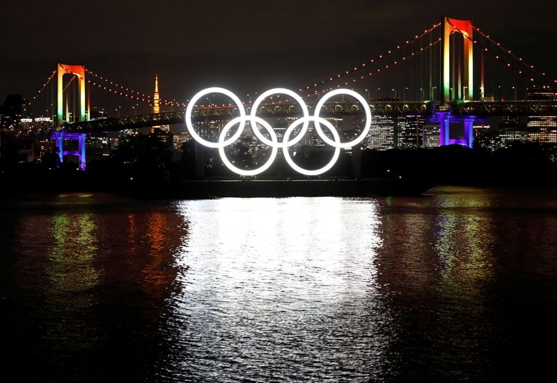 The giant Olympic rings are illuminated after being reinstalled at