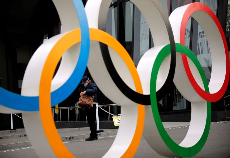 FILE PHOTO: Man is seen through the Olympic rings in