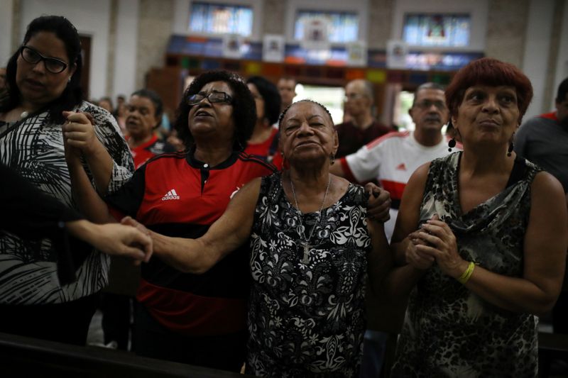 People attend a mass in tribute to fire victims at