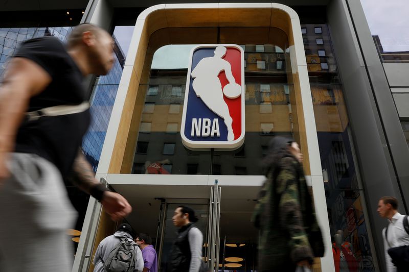The NBA logo is displayed as people pass by the