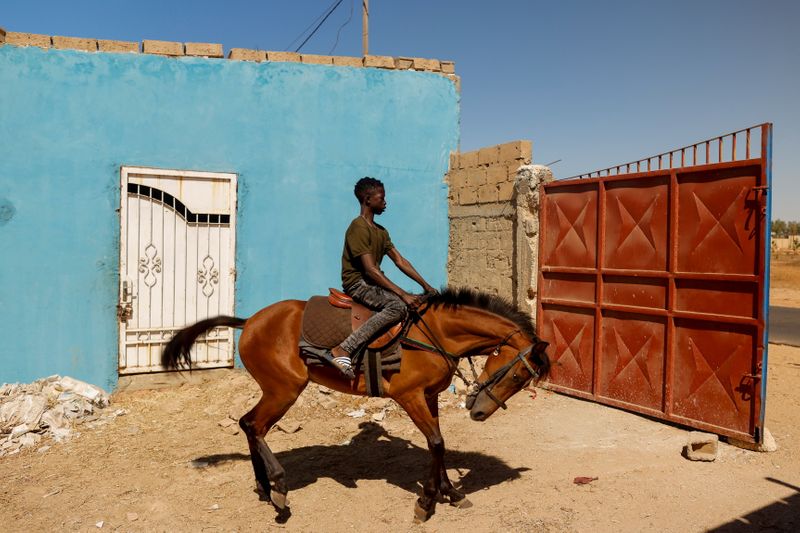 The Wider Image: Meet the teenage Senegalese jockey racing to