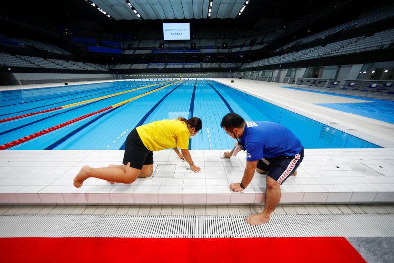 FILE PHOTO: Staff members work next to the swimming pool