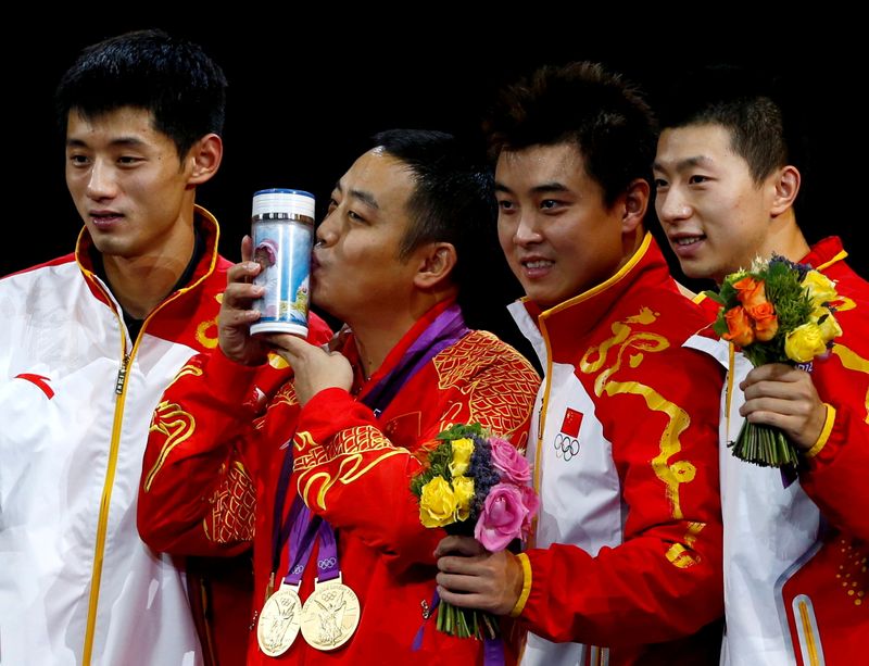 FILE PHOTO: China’s coach Liu Guoliang kisses the trophy as