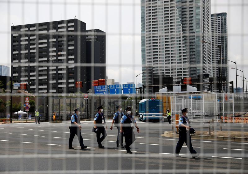 Police officers patrol at the Athletes Village ahead of Tokyo