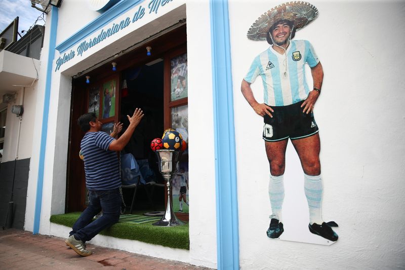 A fan kneels at the entrance to the first Mexico’s